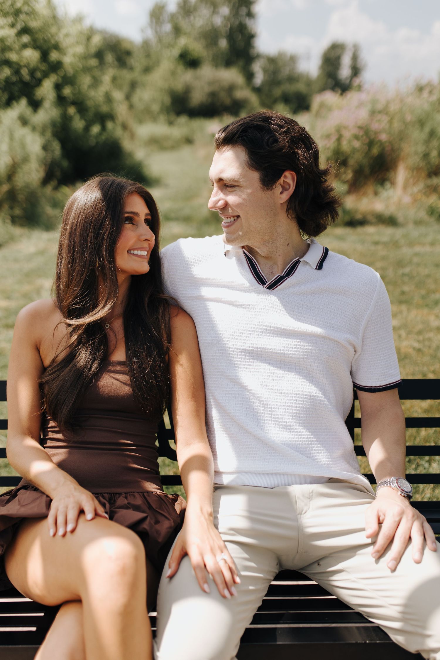 Nature-inspired proposal setting with floral views and woodlands behind couple sitting and soaking up the moment.