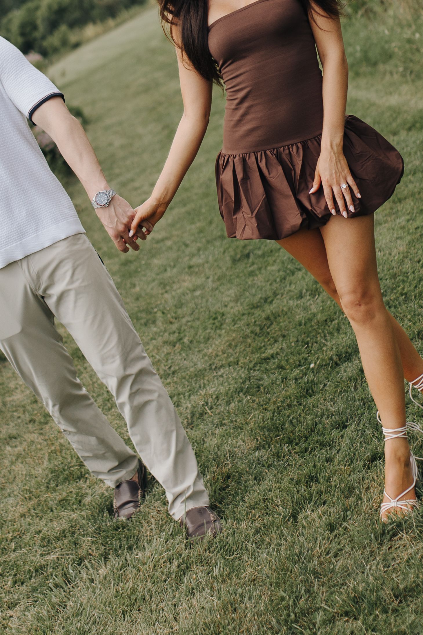 A fun, detail-oriented editorial photo of the two newly engaged couple walking hand-in-hand amongst the flowers at High Banks Metro Park.