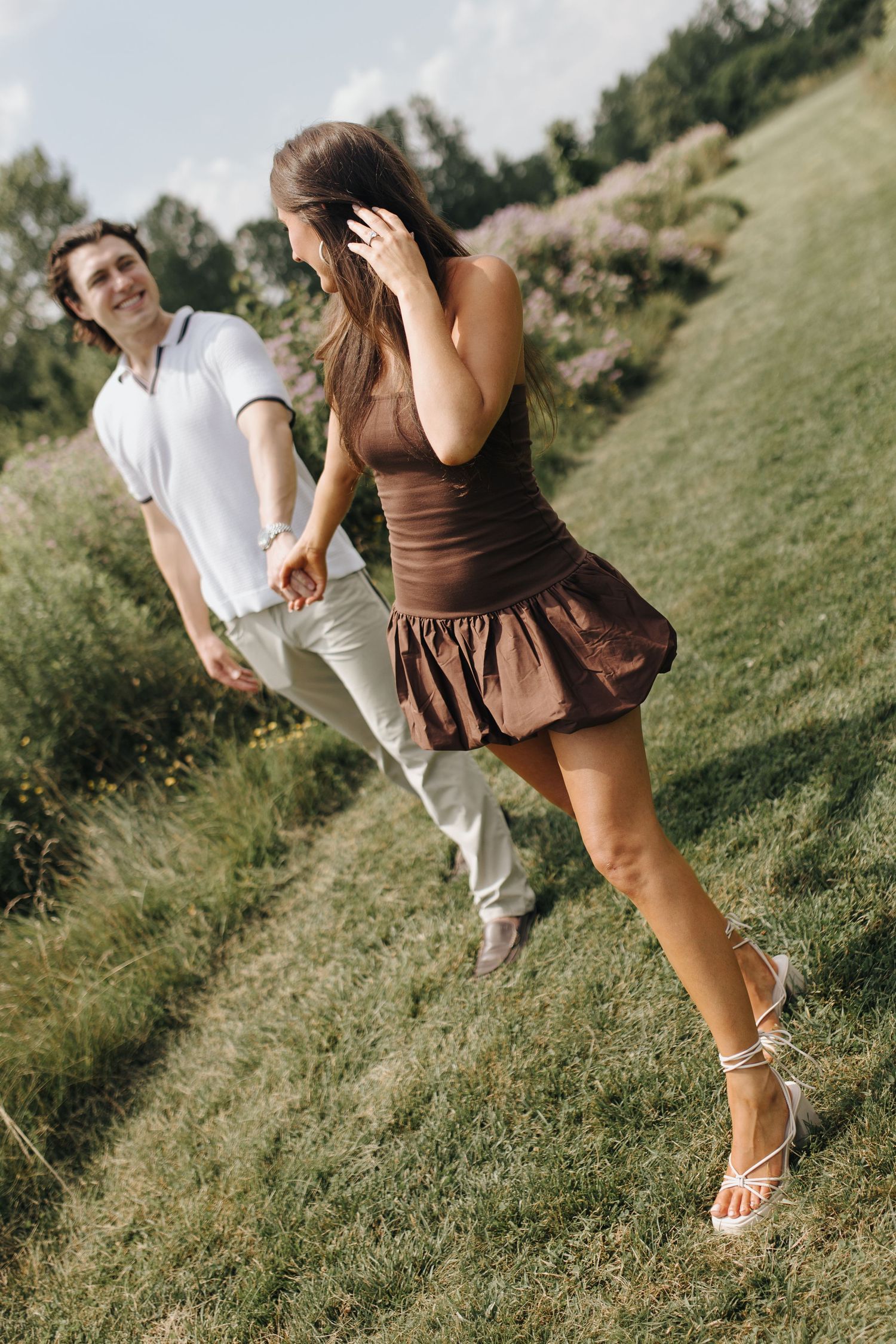 Engagement ring on Brooke's hand as she holds Martin's with the other and they walk happily together.