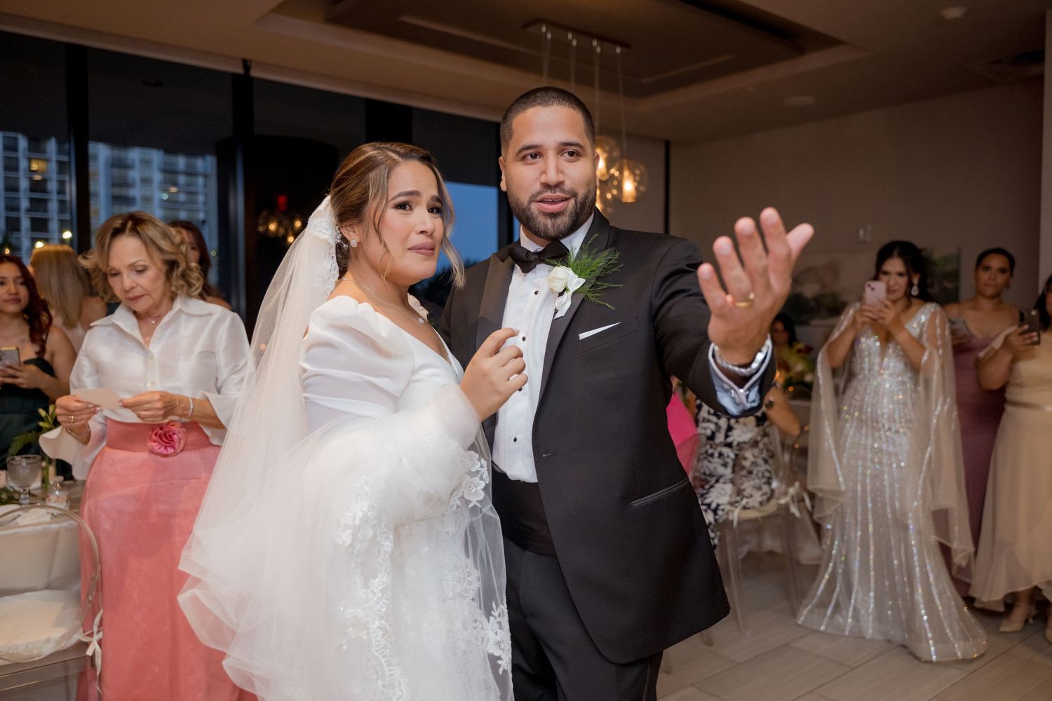 Wedding celebration candids showing guests dancing and celebrating in a reception hall.