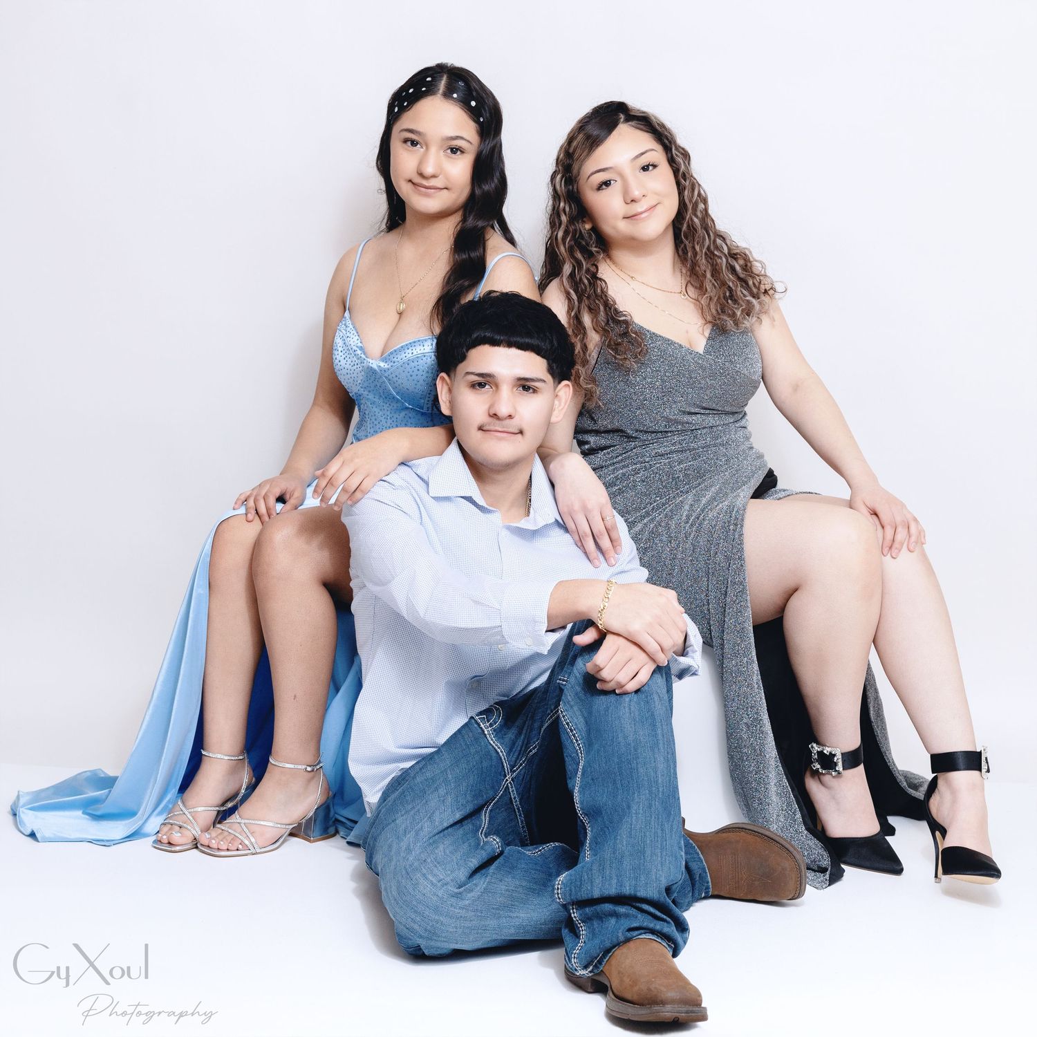 Group of friends wearing coordinating blue and grey outfits relaxing together in casual studio portraits.