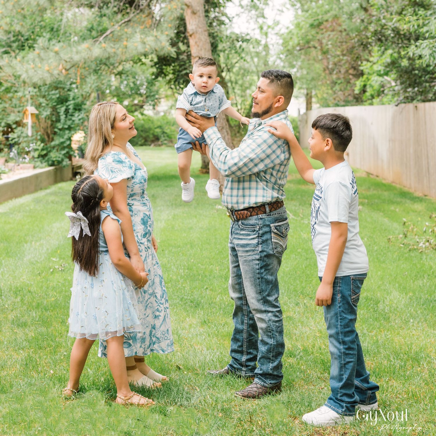 Family spending time together outdoors on a sunny day in their backyard garden.