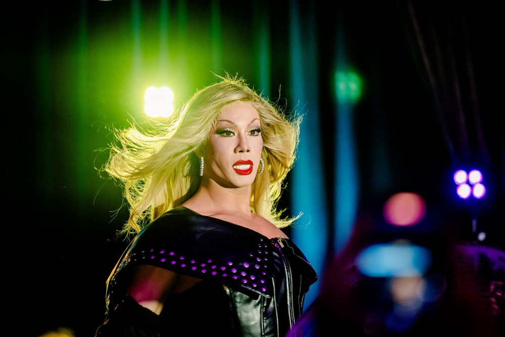 A performance on stage with dramatic lighting effects in green and blue tones highlighting dynamic movement.