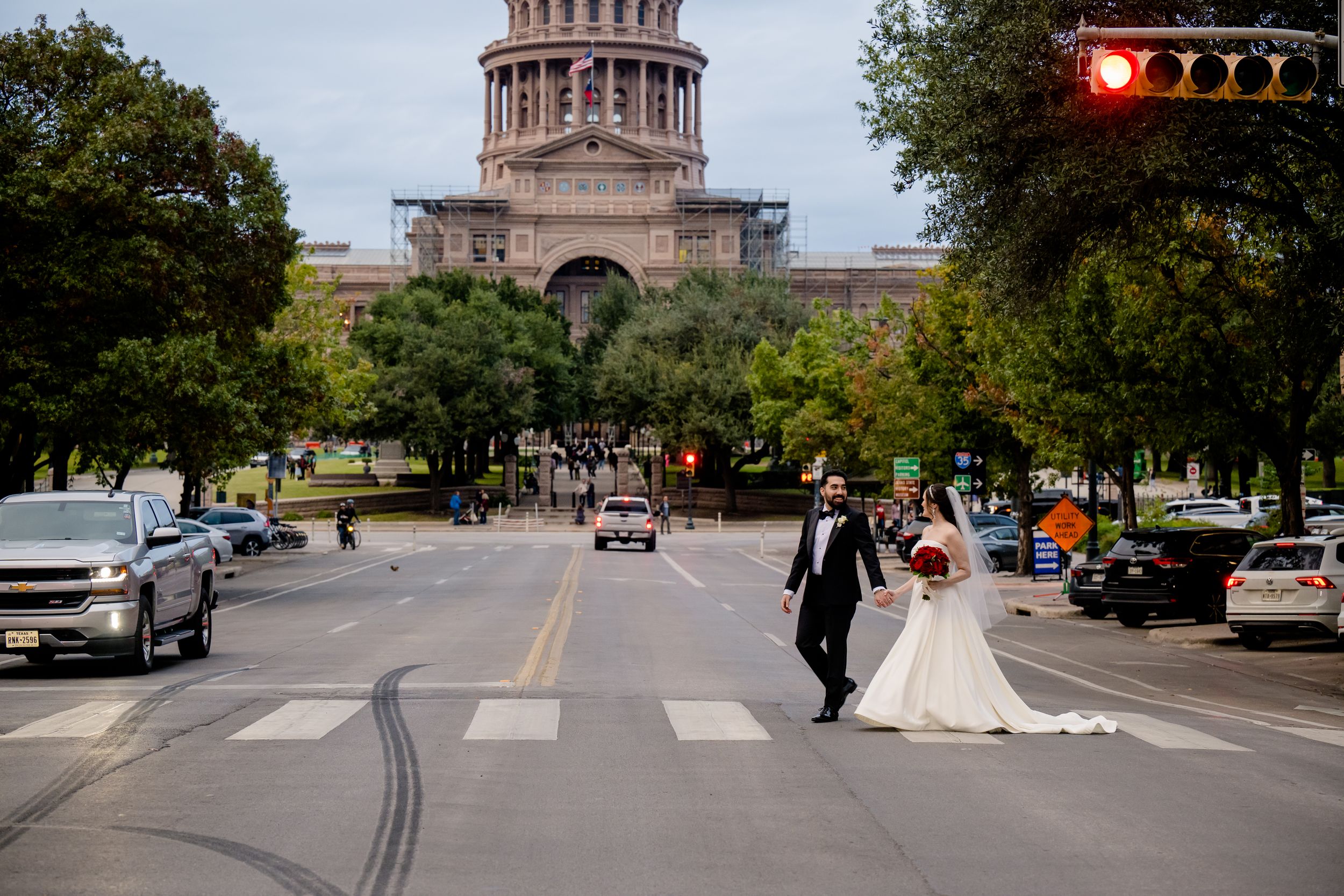 Wedding couple crosses Congress Avenue with the Texas State Capitol building visible in the background.