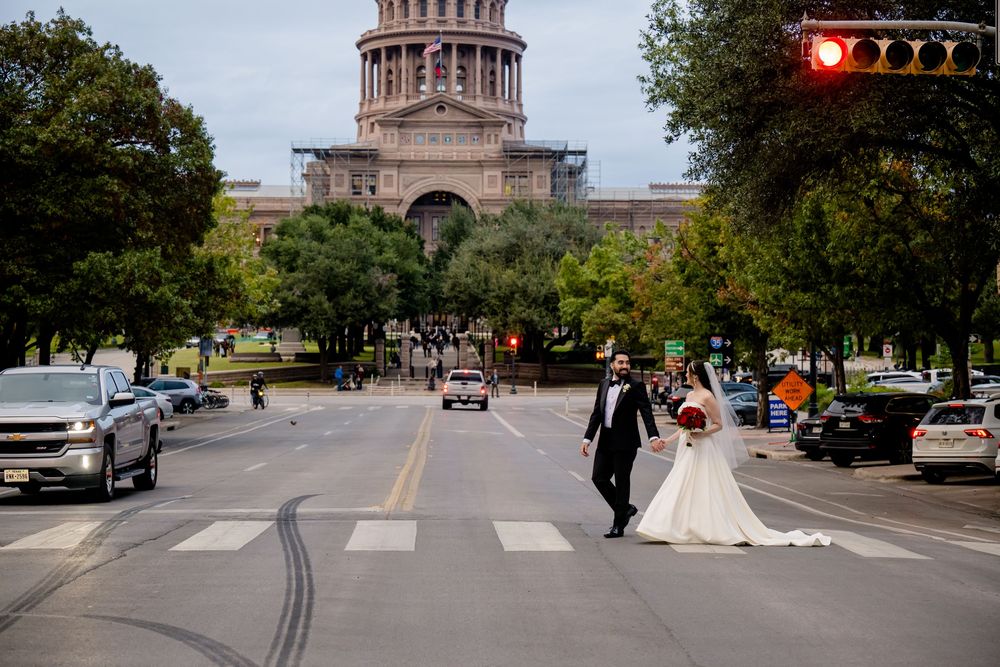 Wedding couple crosses Congress Avenue with the Texas State Capitol building visible in the background.