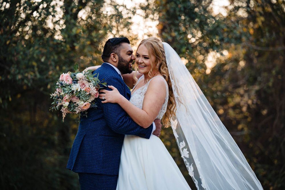 Sunset wedding photography series showing romantic moments between newlyweds in blue suit and white dress with veil.