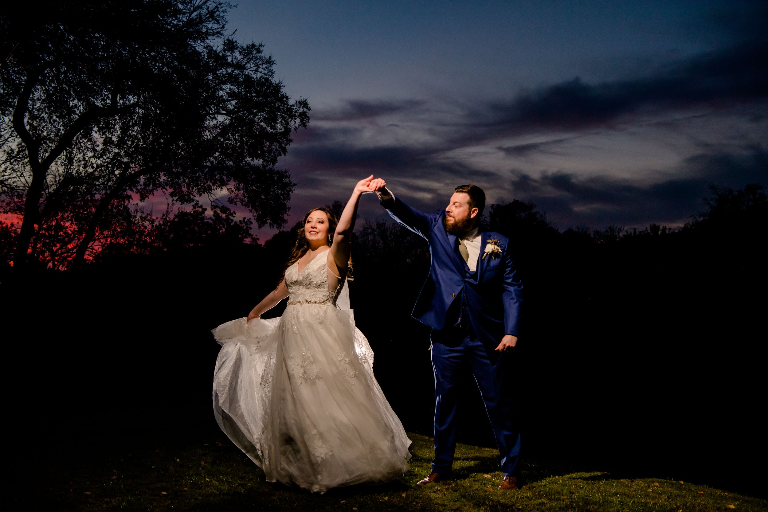 Two people share intimate dance poses during sunset at a romantic outdoor wedding photoshoot.