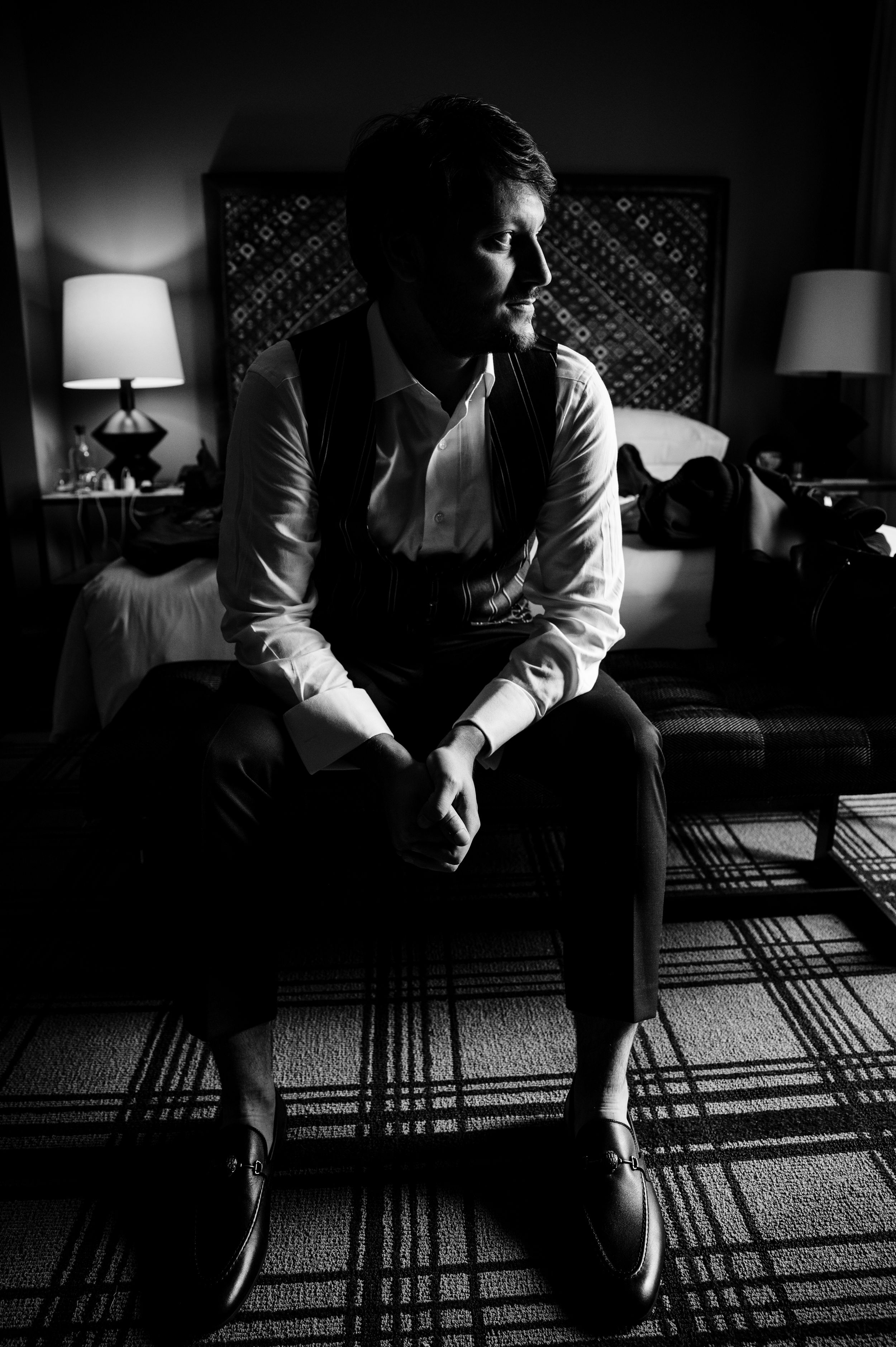 Dramatic black and white photo sequence of a seated figure casting long shadows through window blinds on a carpet.