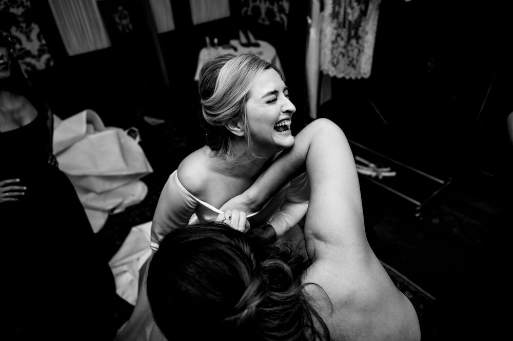 Intimate black and white photograph shows a sensual moment between two people in a dimly lit room.