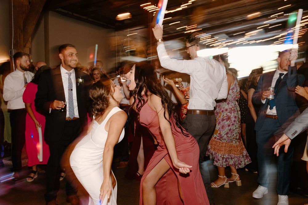 Couples dancing and celebrating together on a crowded dance floor at a lively party or reception.