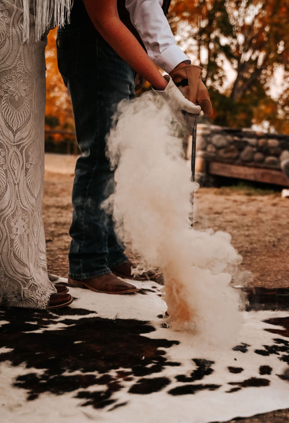 Artistic photo capturing dust or smoke against a rustic background with cowboy boots visible.