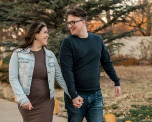 Couple walking hand in hand wearing matching casual outfits during fall season.