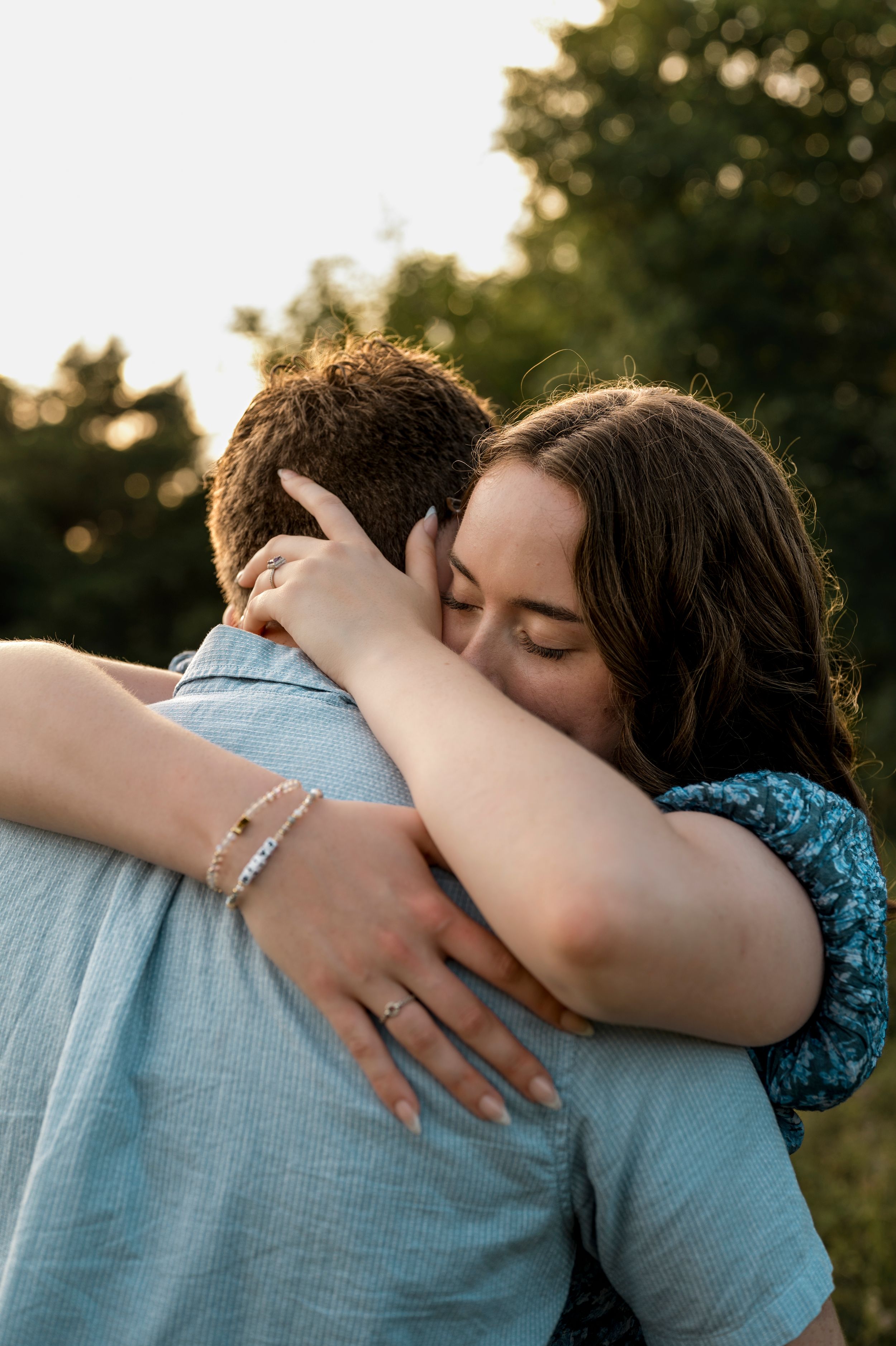 A tender embrace showing genuine affection during golden hour in a natural outdoor setting.