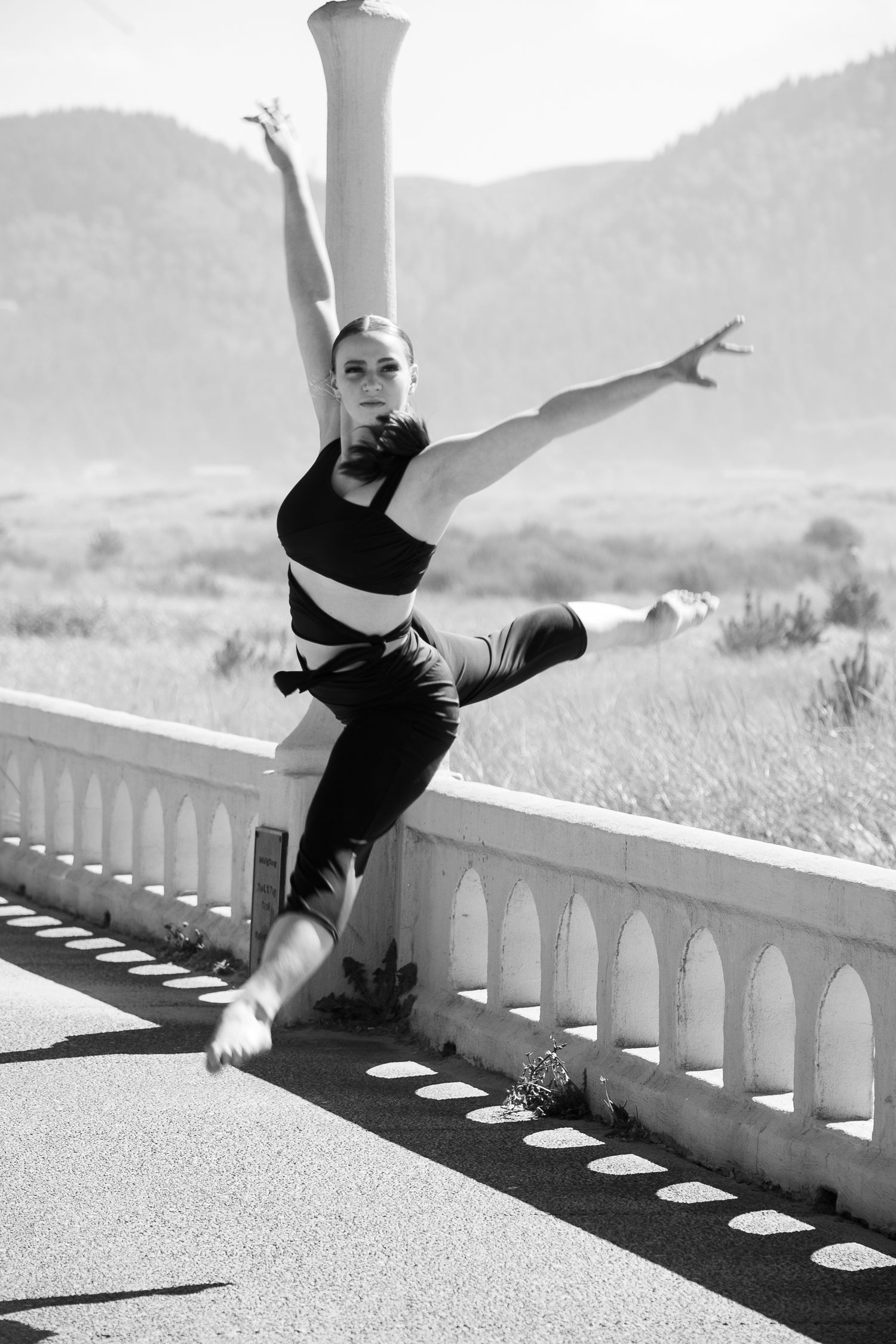 Black and white photo of dancer jumping on the beach