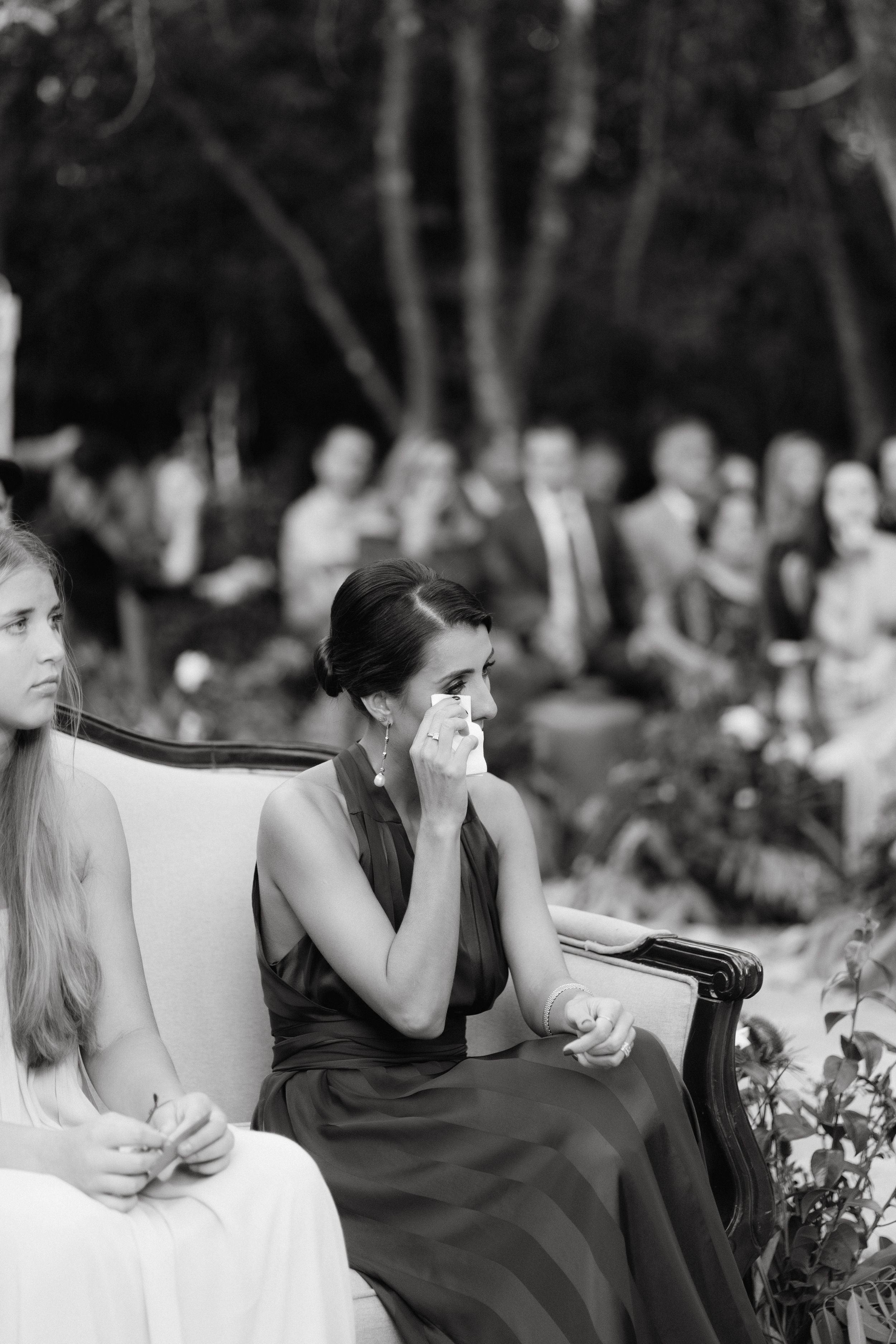 Black and white photo captures emotional reactions during wedding speeches.