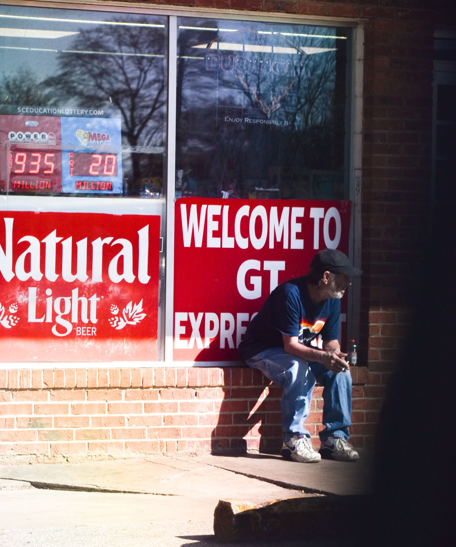 A storefront with Natural Light and Welcome signs in red lettering.