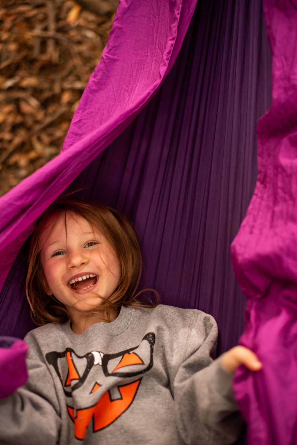 Colorful moment in a bright purple outdoor hammock.
