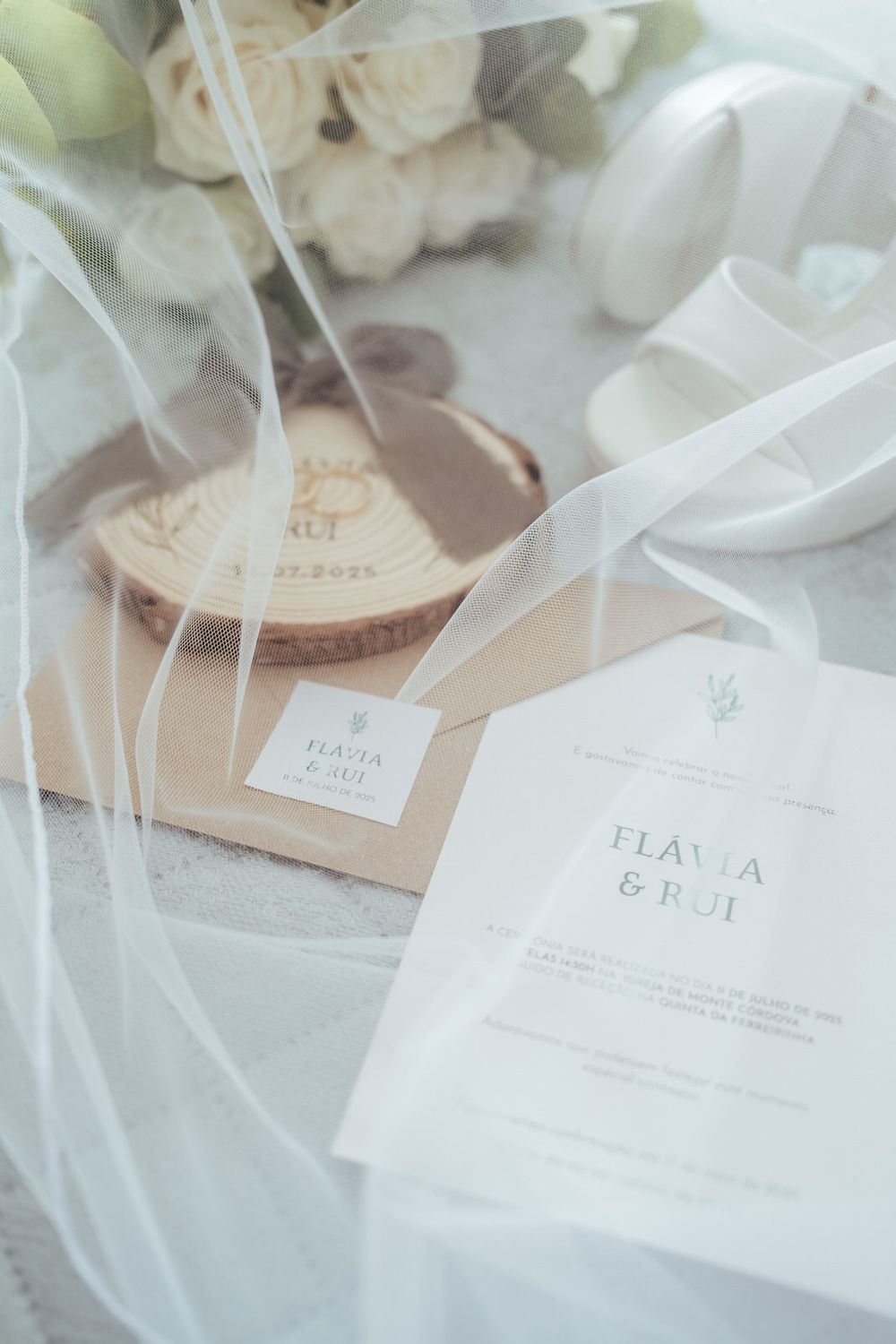 Elegant wedding stationery suite featuring Flavia and Rui invitation cards with white roses and tulle veil.
