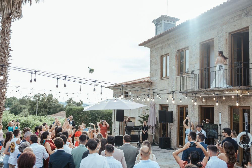 Outdoor wedding reception with live band performance at a rustic stone venue with string lights and guests dancing.