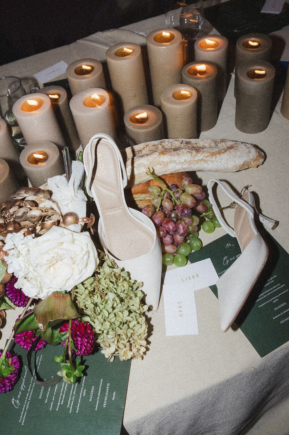 Romantic reception setup featuring elegant candles, florals and natural textures