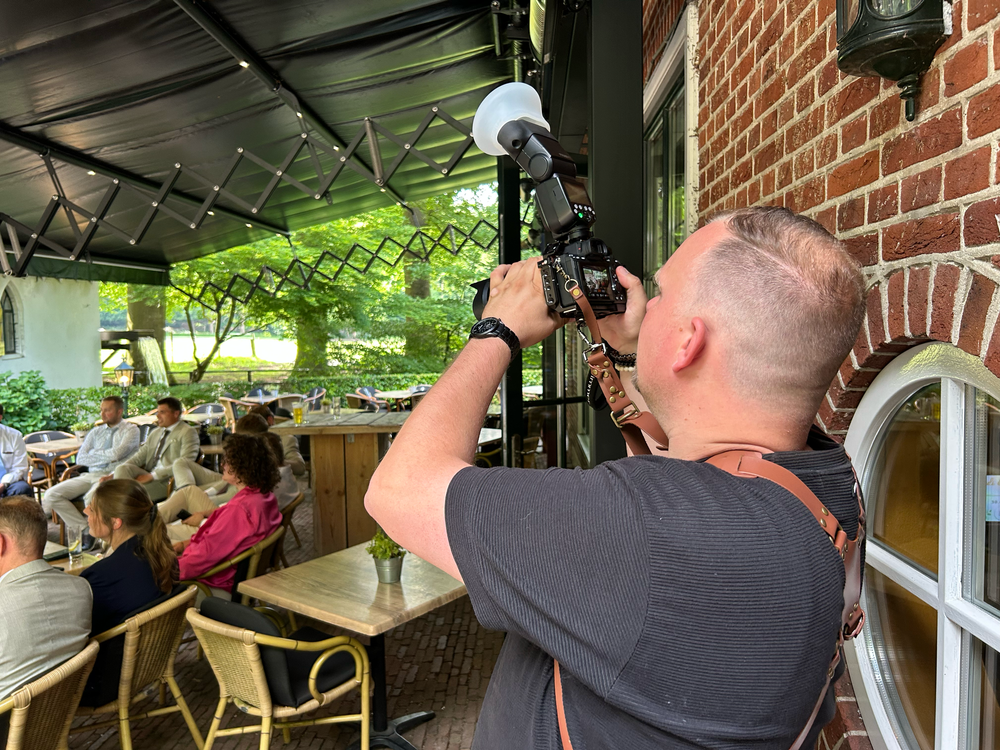 Professionele fotograaf legt spontane momenten vast op een buitenlocatie voor een bruiloftsreceptie.
