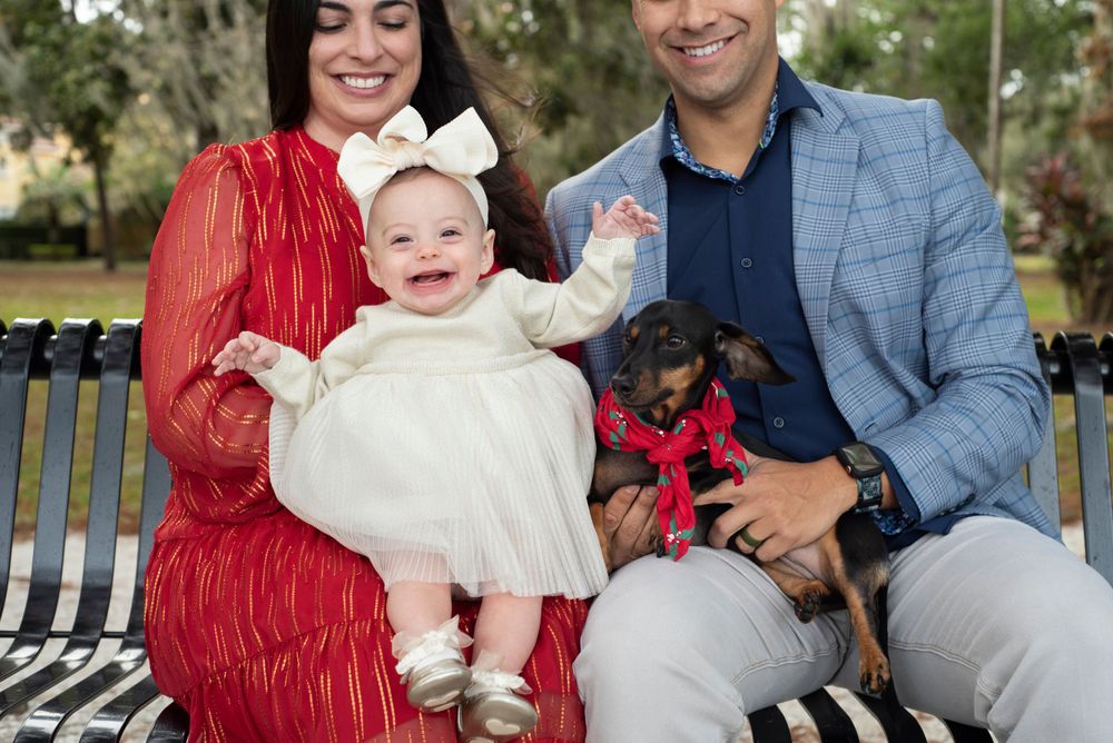Family christmas portrait session baby girl and pet natural afternoon lighting in Orlando Florida at Kraft Azalea Gardens
