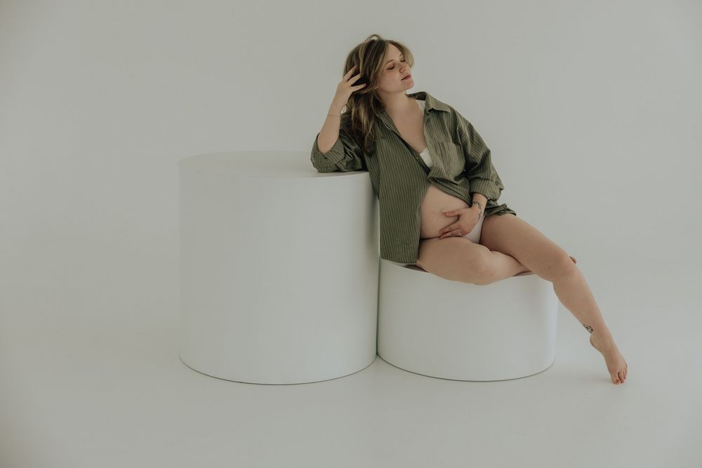 Rochester, NY family photographer capturing a maternity session in a studio.