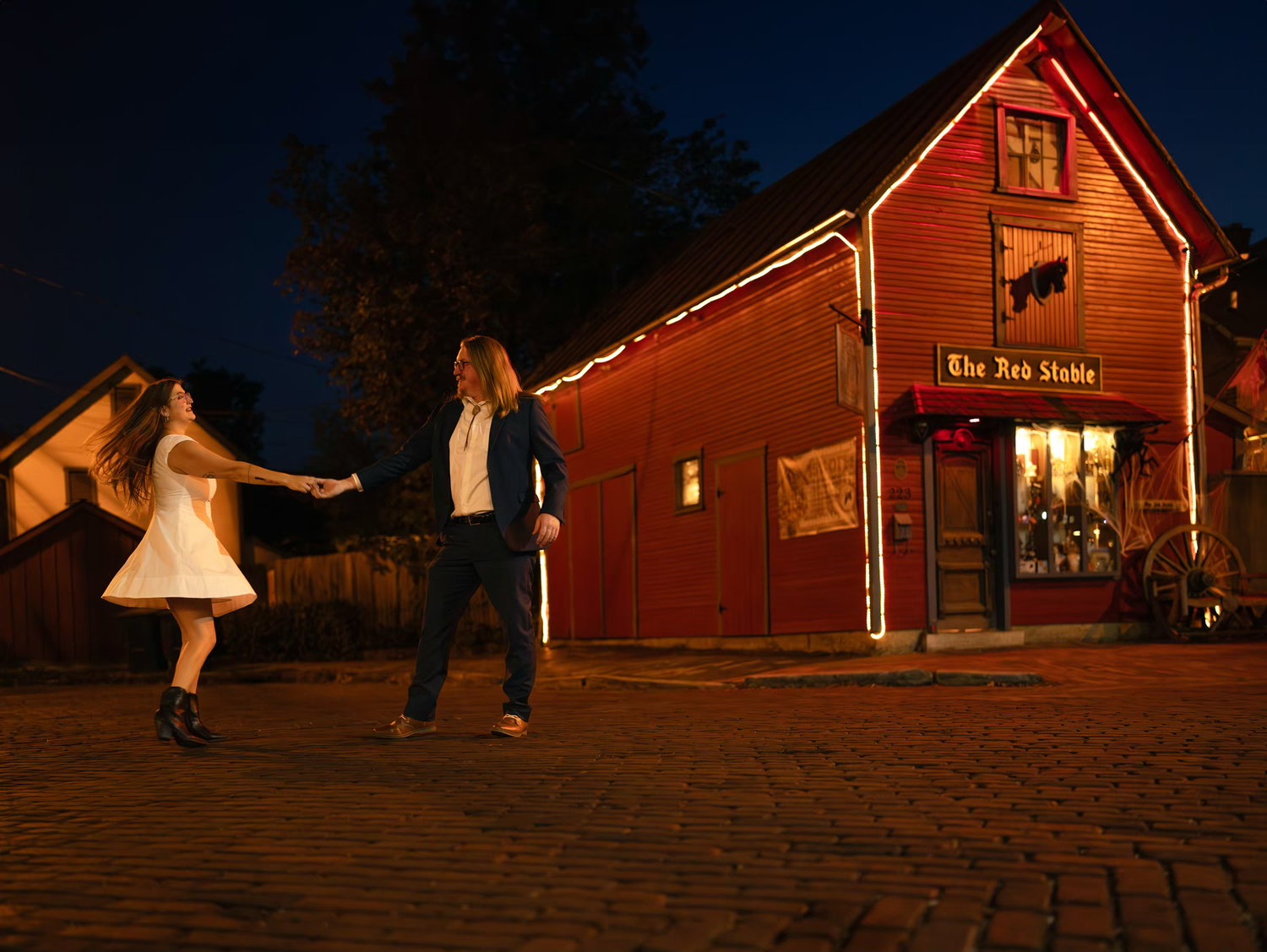 Couple dancing outside The Red Stable rustic red barn building at night in German Village Engagement Photos