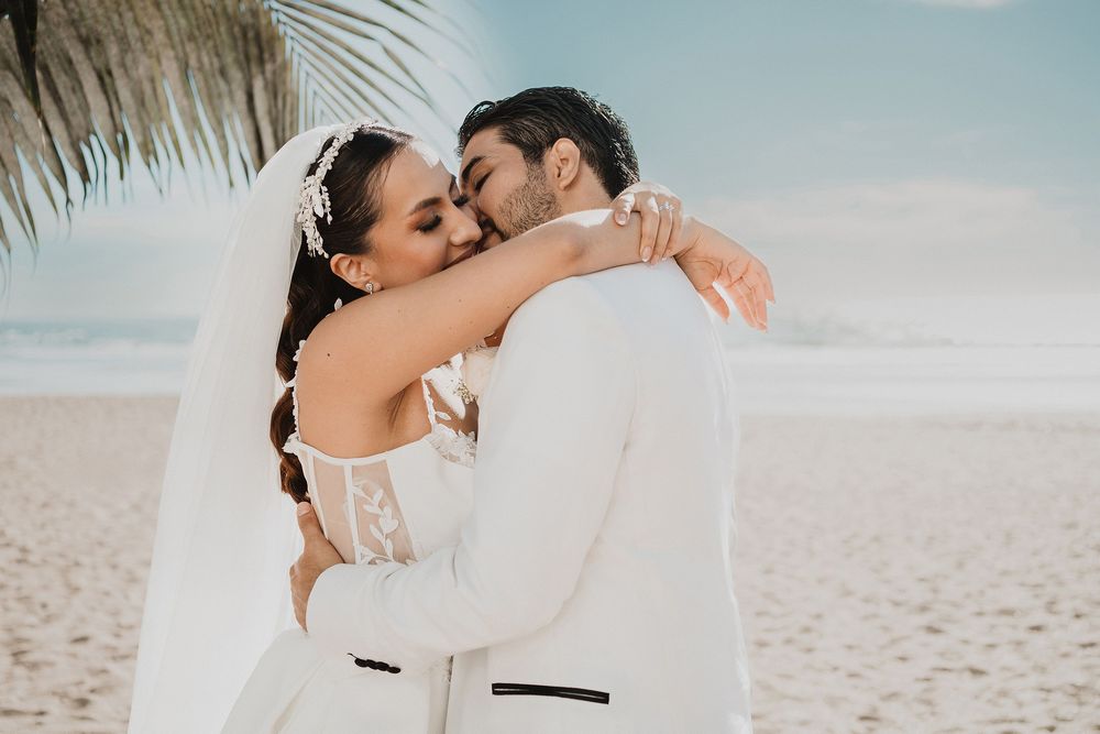 Boda íntima en playa en Mazatlán abrazándose después de la ceremonia, fotografía natural y emocional por Carlos Galindo Wedding Photographer