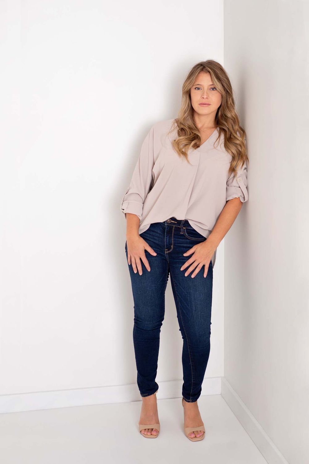 Modern dressed business woman stands against a white wall for her branding session in Baltimore, Ontario*