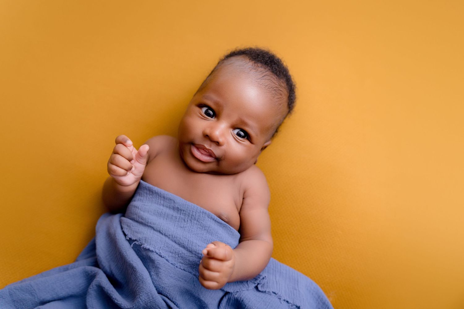 Newborn photoshoot Saskatoon and Warman, wrapped baby newborn boy in bright beautiful colors