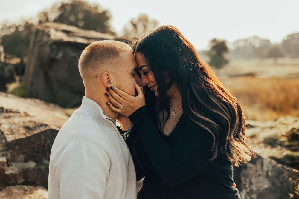 Romantic sunset engagement photos captured in warm golden light across panoramic mountain landscapes.
