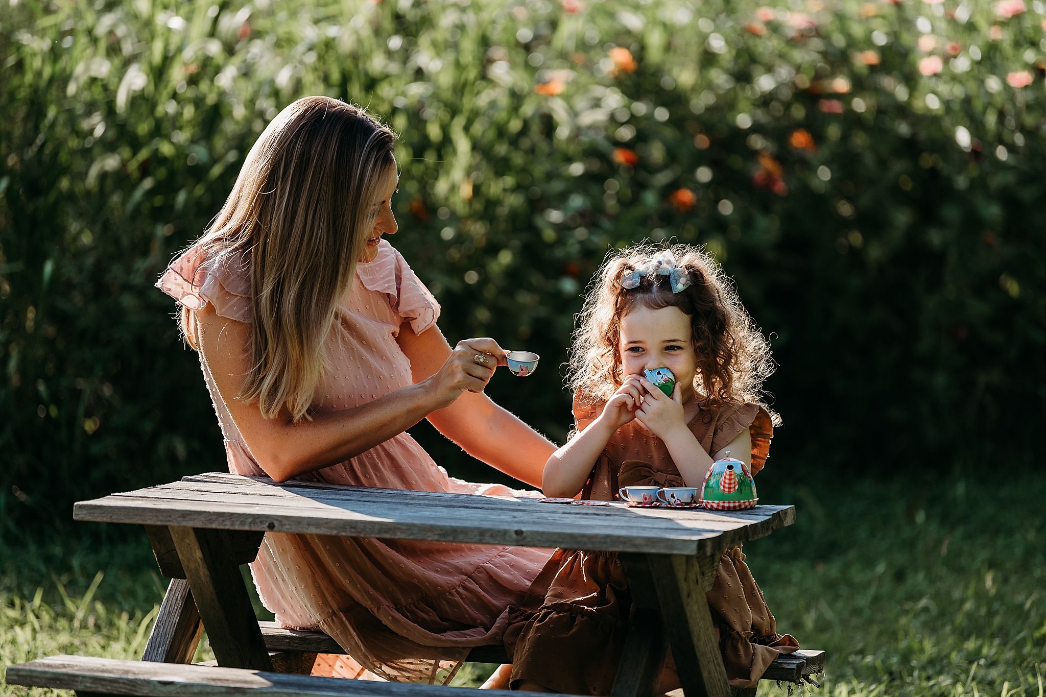 A series of outdoor photos showing parent and child reading and bonding together on wooden picnic tables.