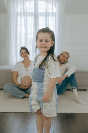 Family enjoying relaxed moments together on a bright wooden floor at home.