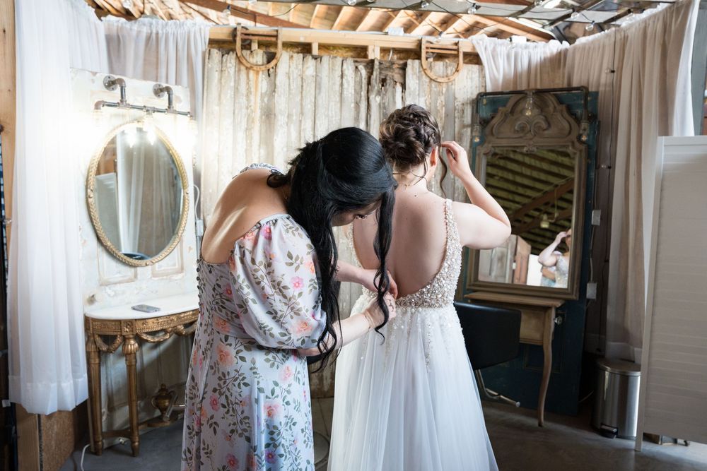 Black and white candid photo showing guests and wedding party preparing in an elegant dressing room.