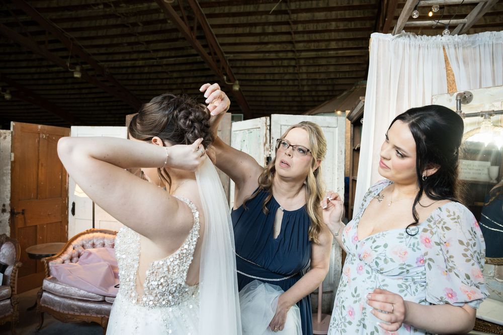 Wedding party gathers for a series of candid moments during preparations and celebrations in a rustic venue.
