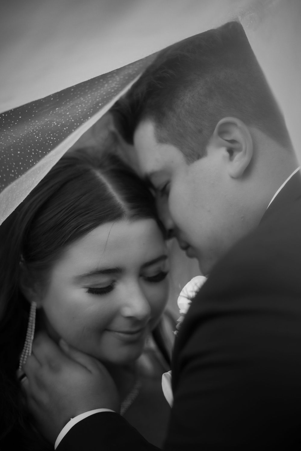 Black and white romantic close-up series showing tender moments between a couple on their wedding day.