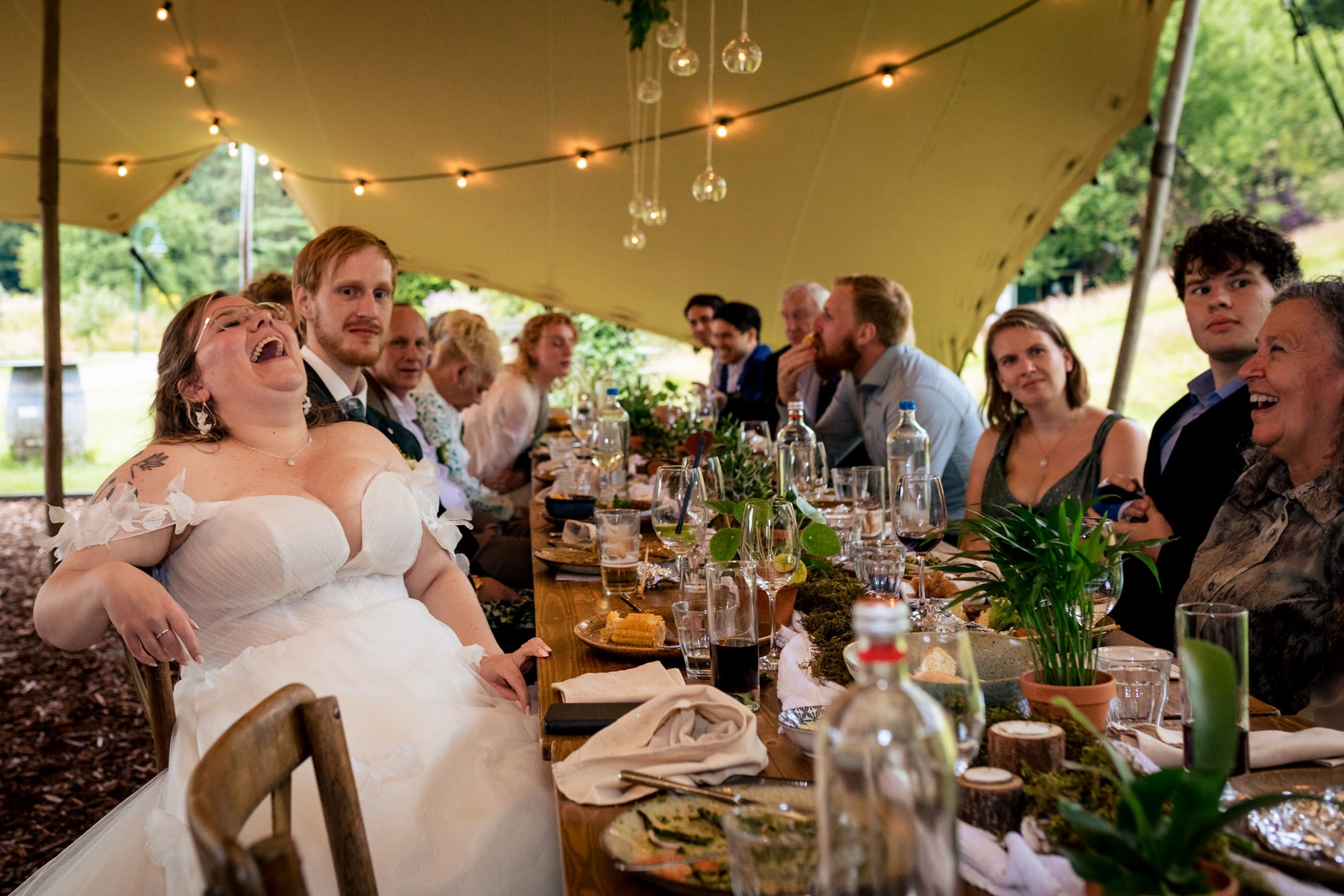 Familie en vrienden luisteren naar speeches tijdens het diner op de trouwdag