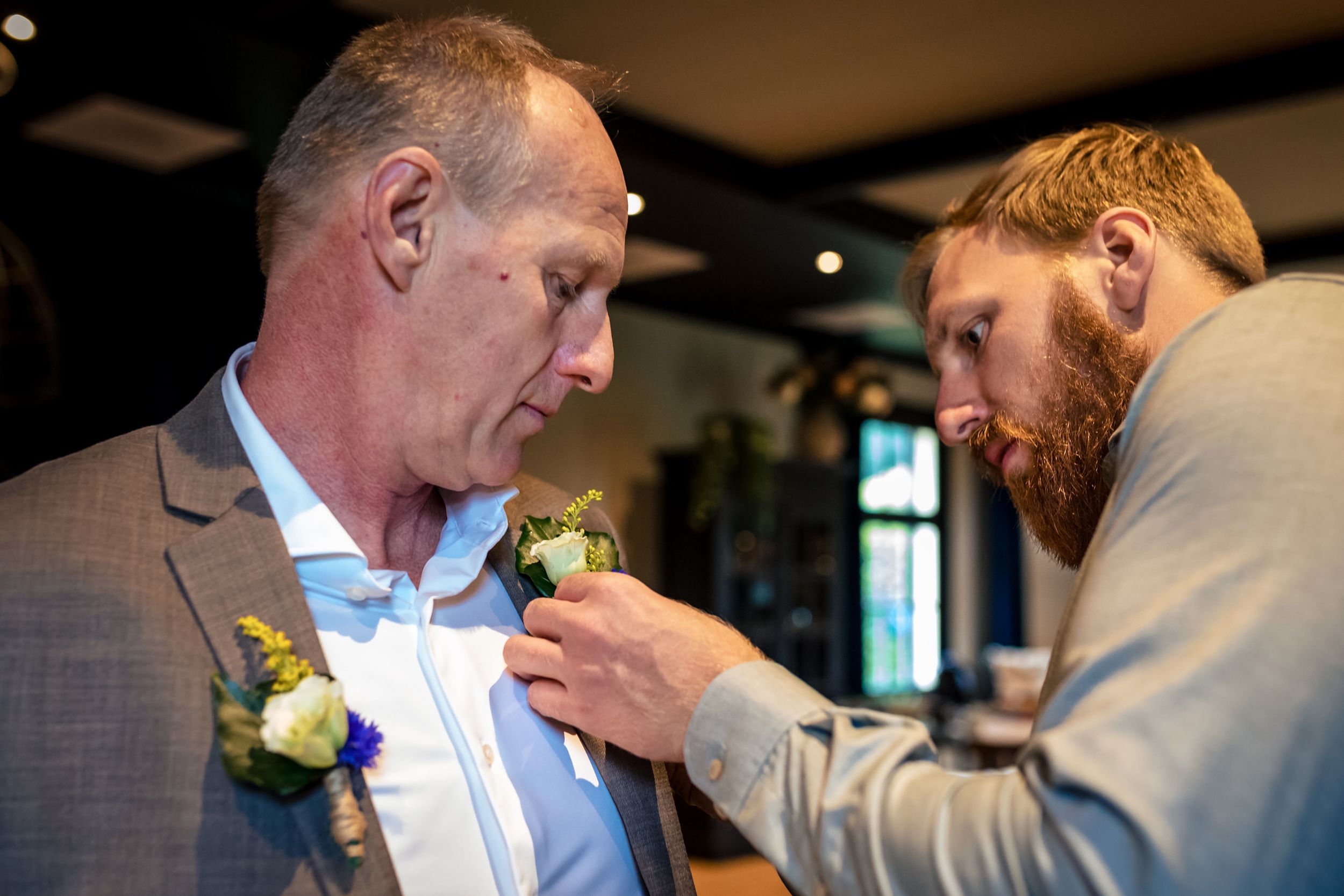 Gast speldt een corsage op tijdens de voorbereidingen van de trouwdag