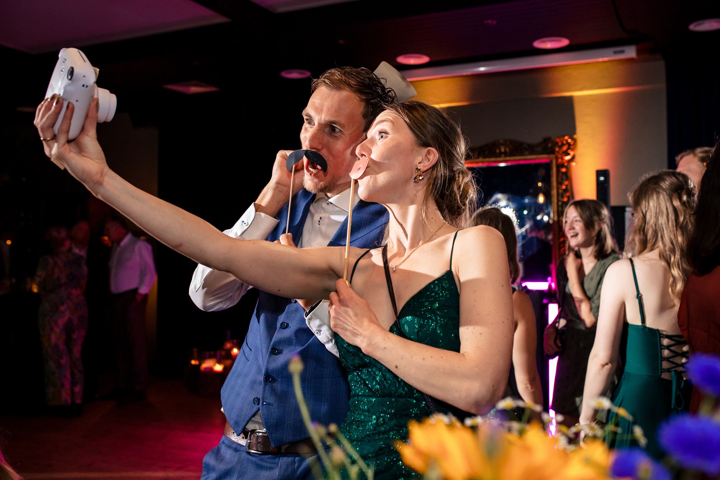 Gasten maken polaroidfoto’s voor het gastenboek tijdens het trouwfeest