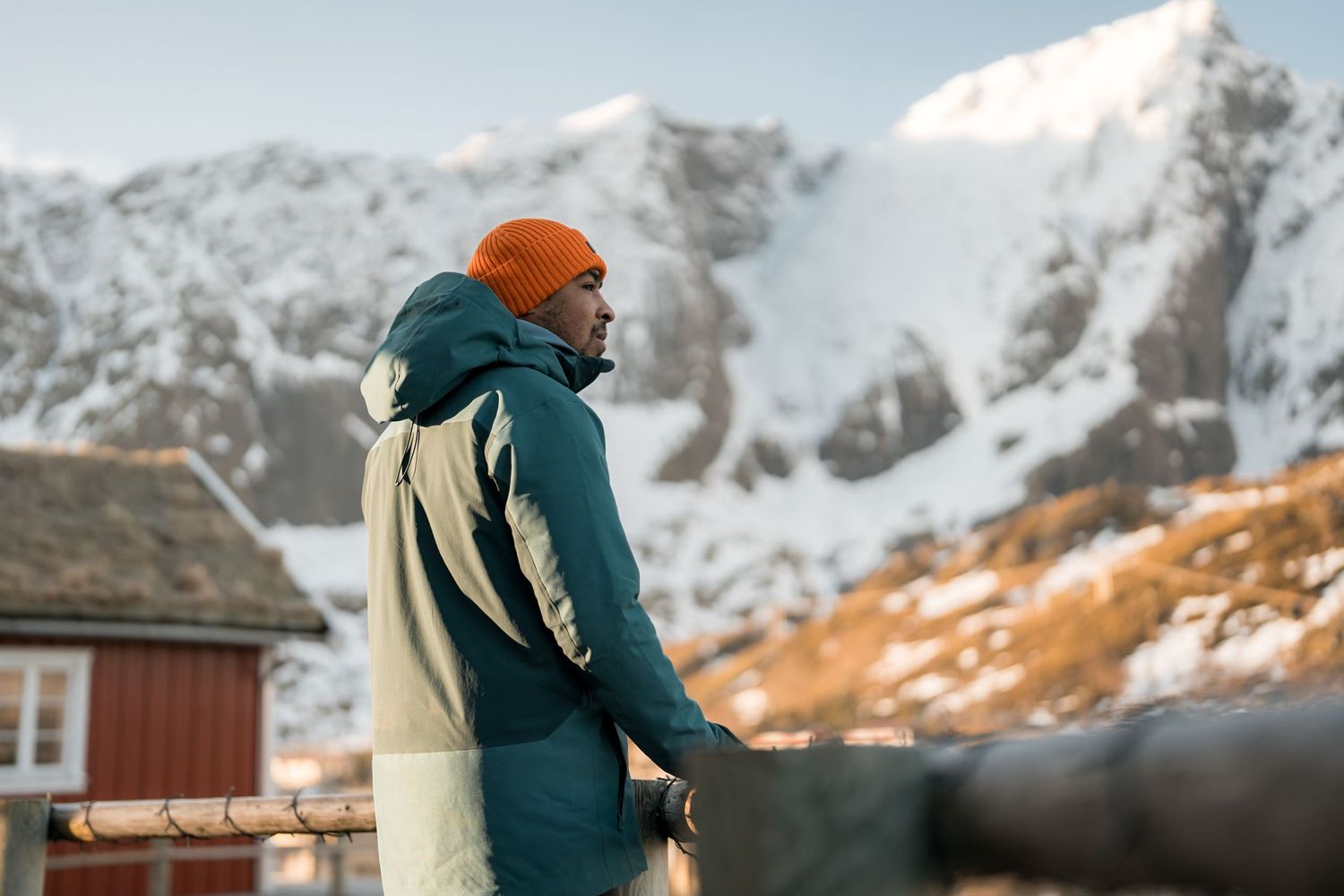 homme devant les montagnes et rorbu de reine