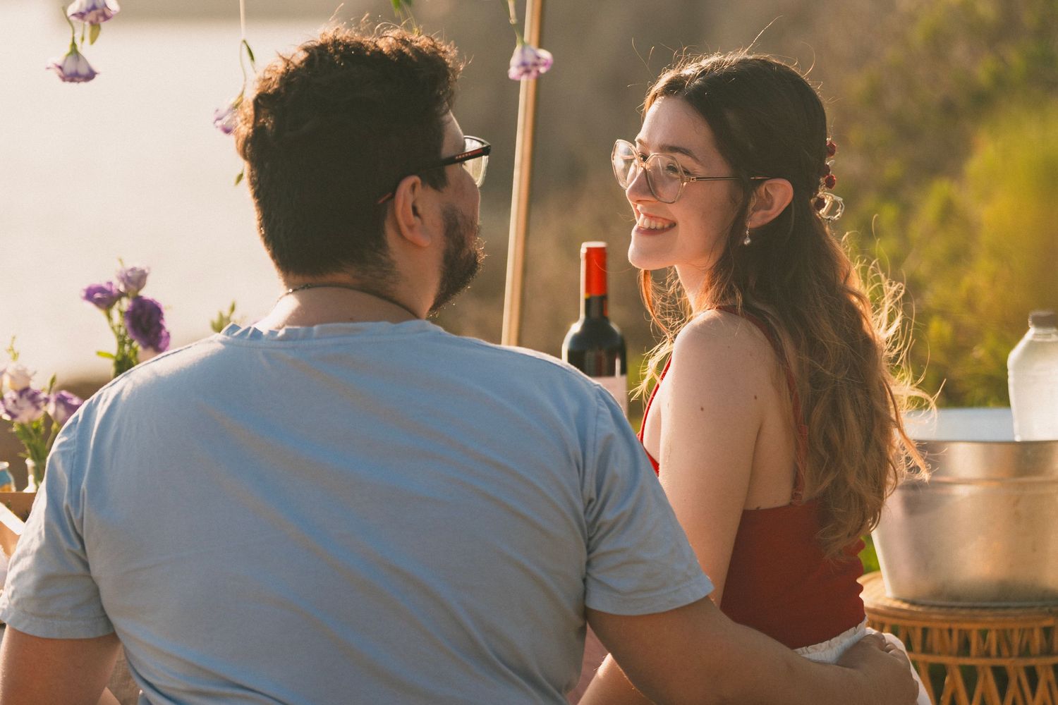 Una pareja en un jardín con palmeras durante un día soleado, en una escena natural ideal para una sesión fotográfica romántica en Mallorca.