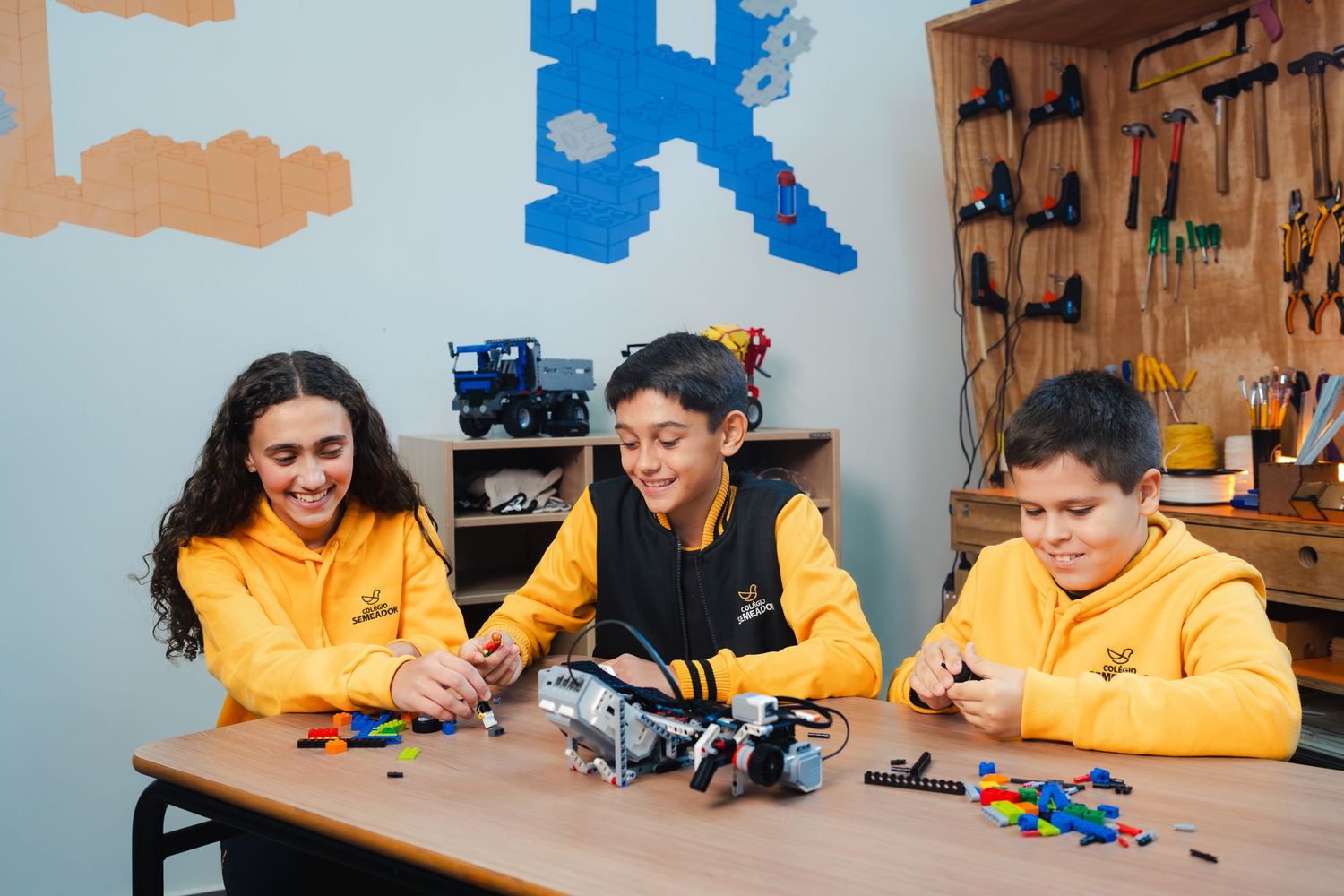 Alunos trabalhando em projetos de robótica e engenharia em uma oficina. Campanha para instituição de ensino.