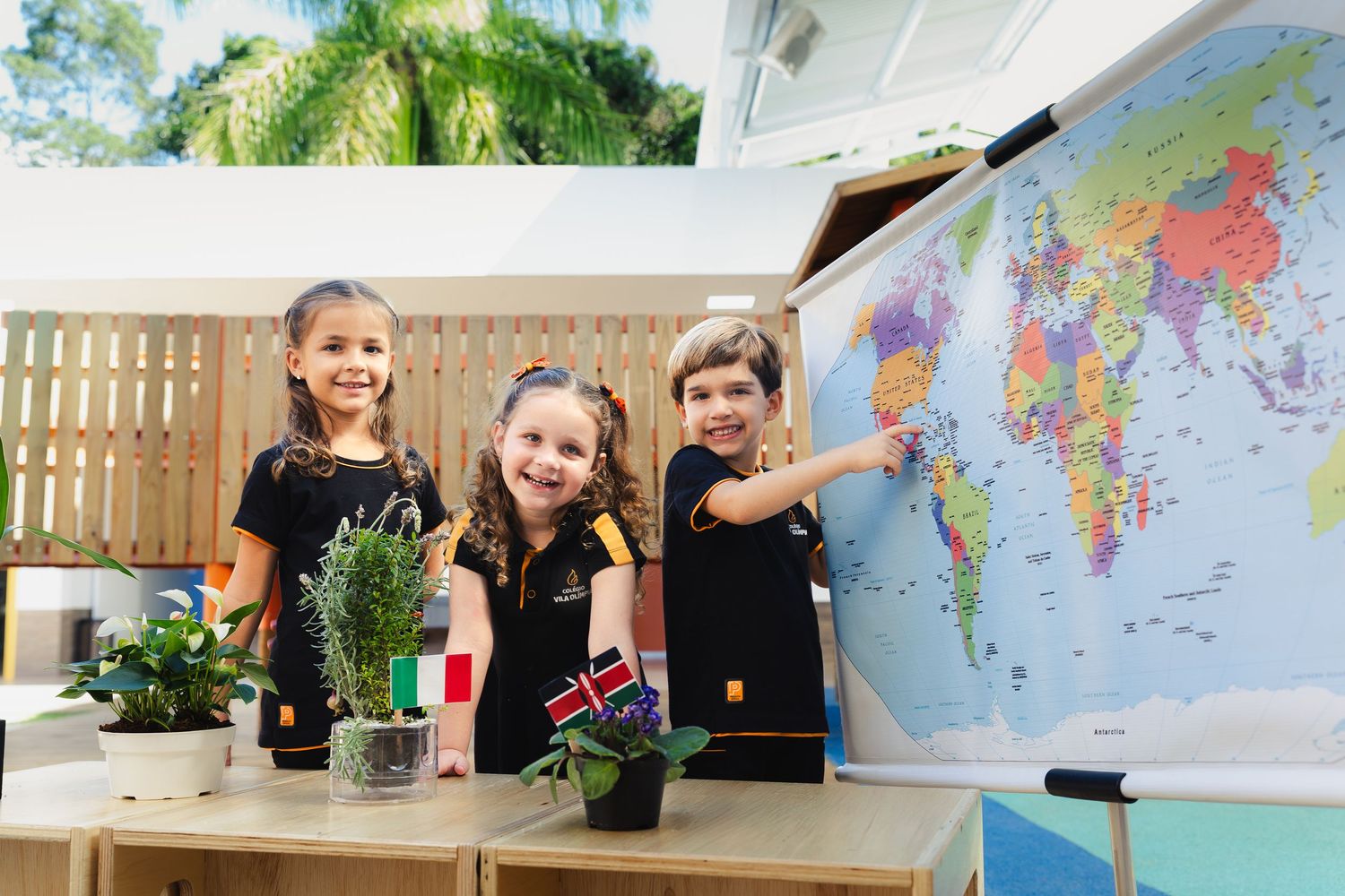 Jovens estudantes aprendendo sobre geografia com um mapa-múndi e plantas em um ambiente ao ar livre. Campanha para instituição de ensino.