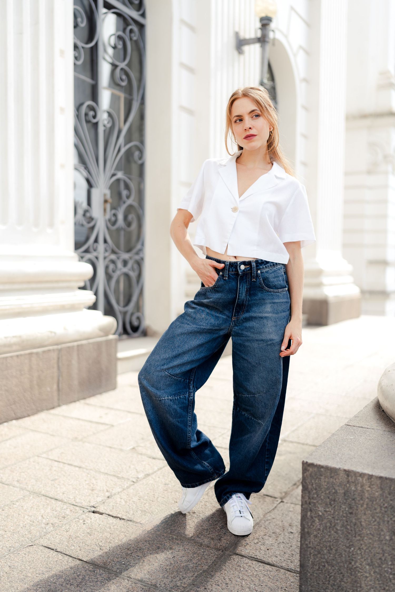 Street style photo series with white shirt and baggy jeans against classical architecture.
