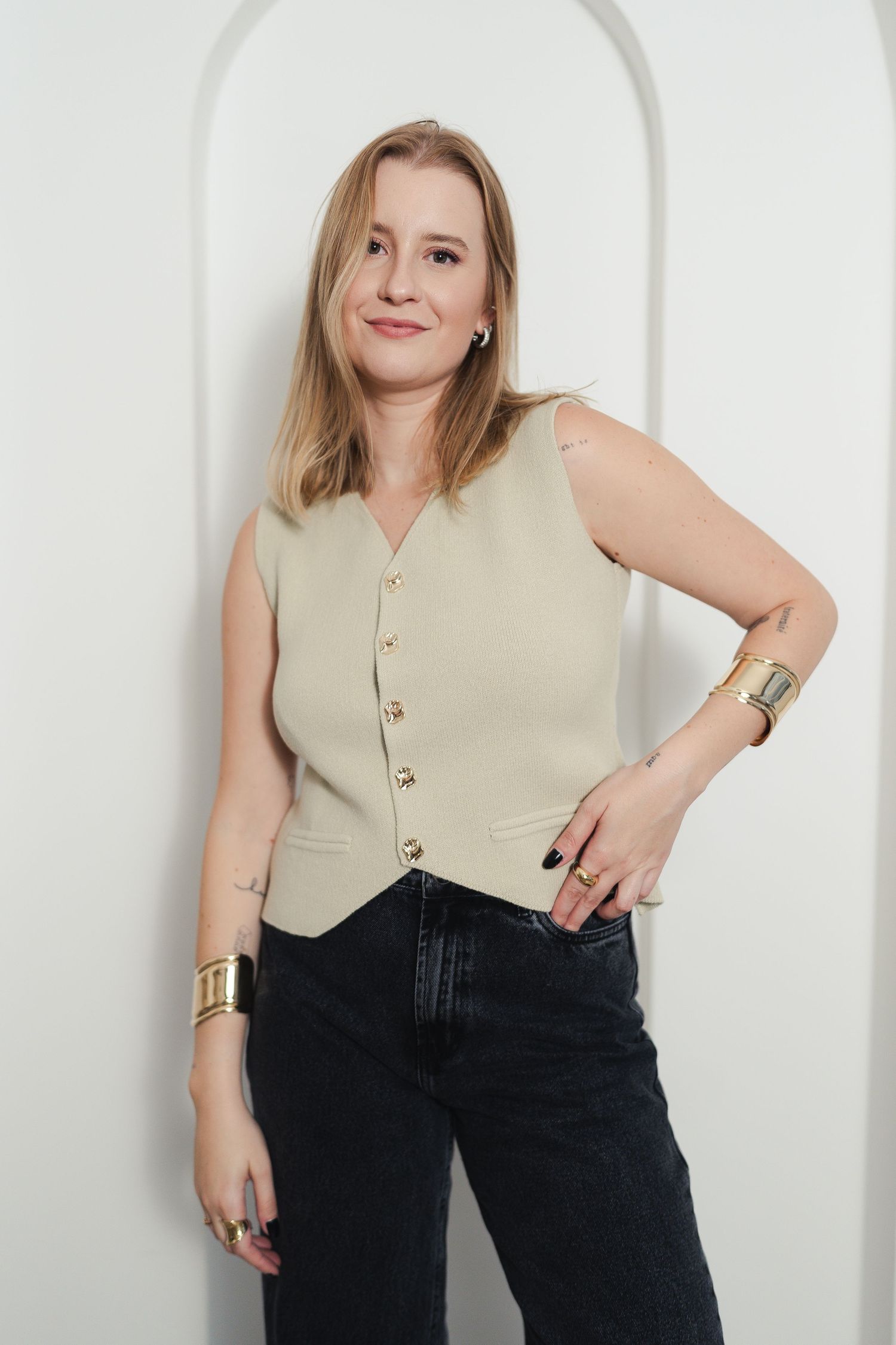Fashion photography series showing a beige sleeveless top paired with dark jeans against a white backdrop.