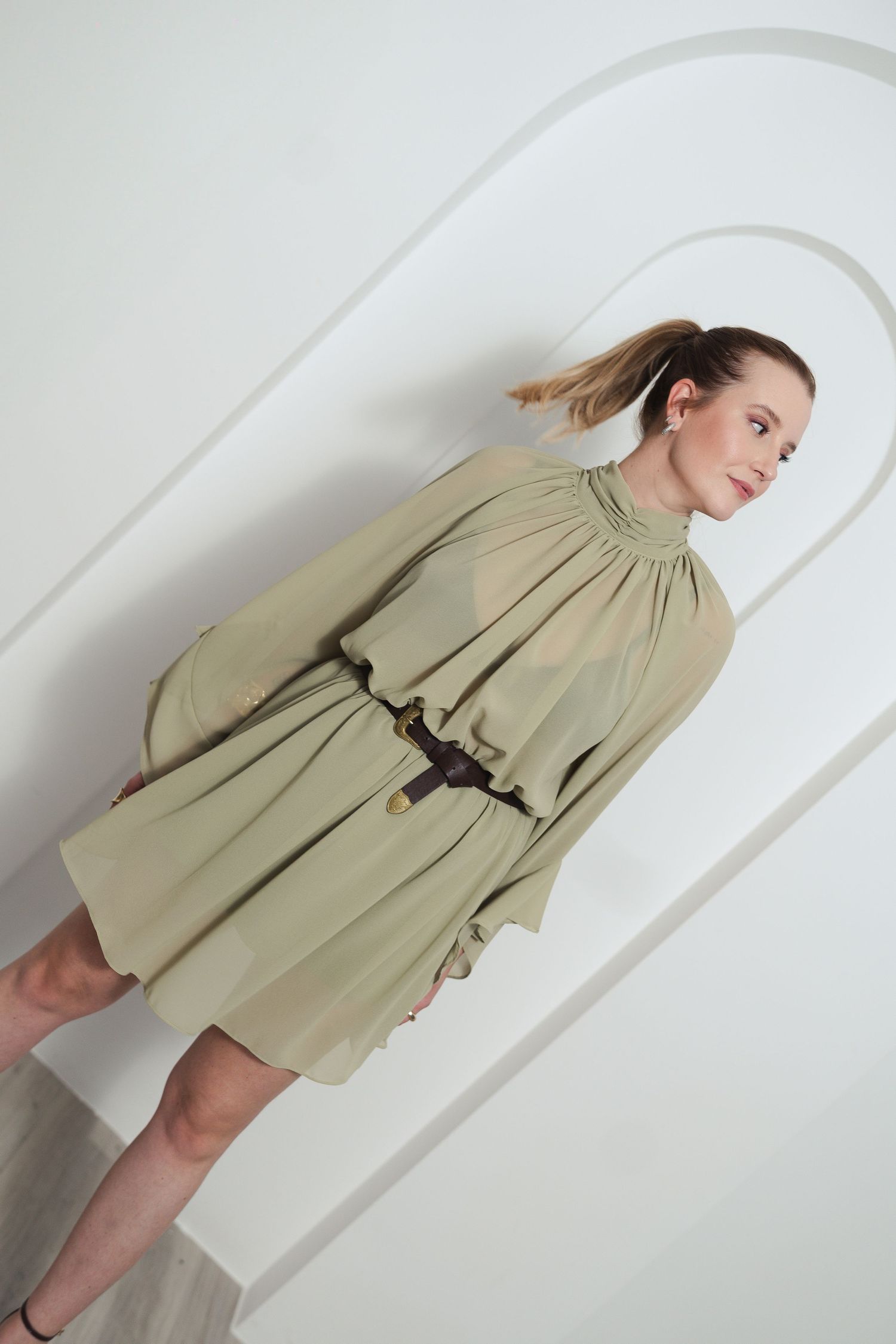 Stylish olive green dress photographed from different angles in a minimalist studio setting.
