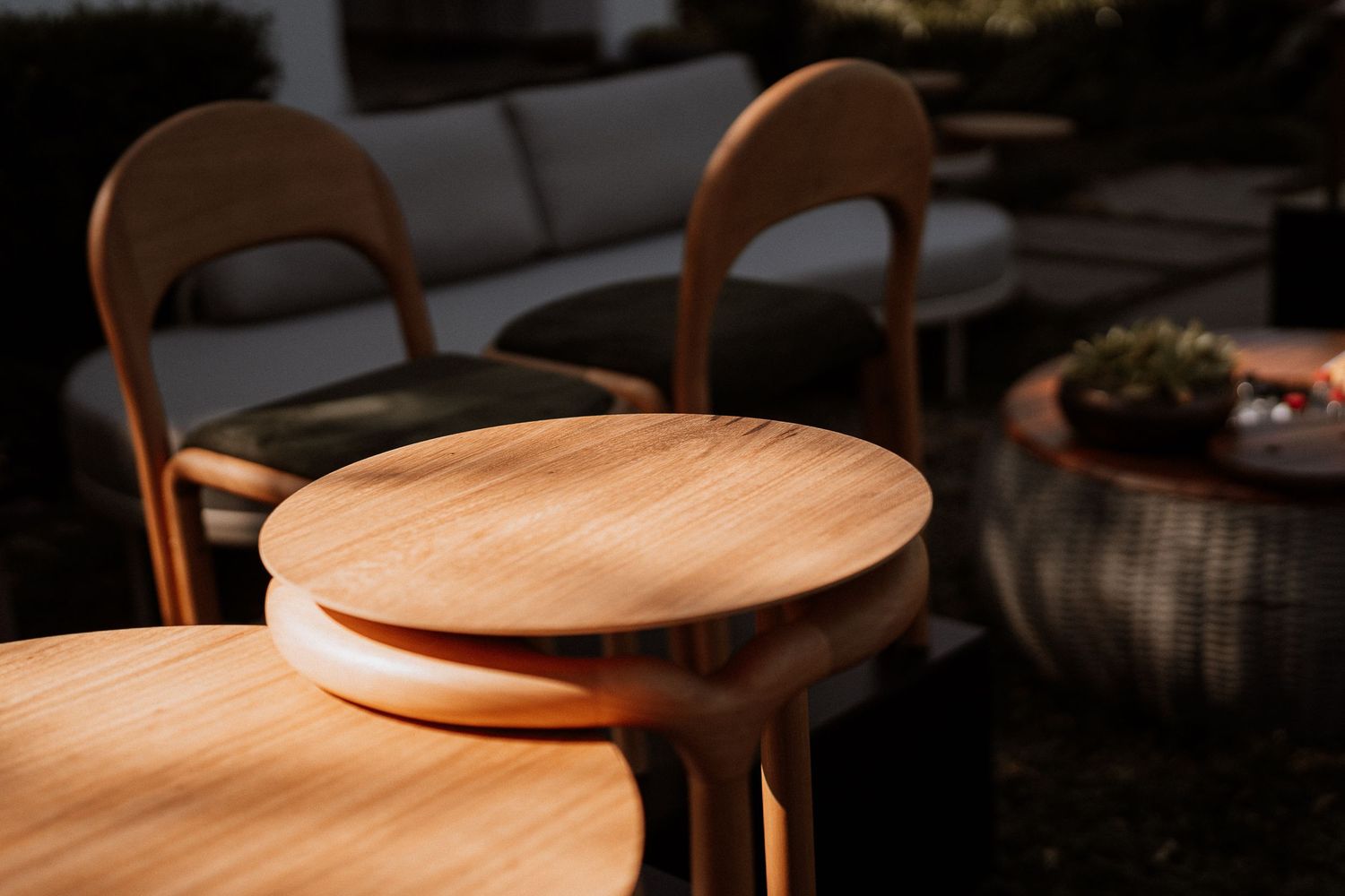 Wooden chair seats and backs cast dramatic shadows in natural sunlight creating an artistic pattern.