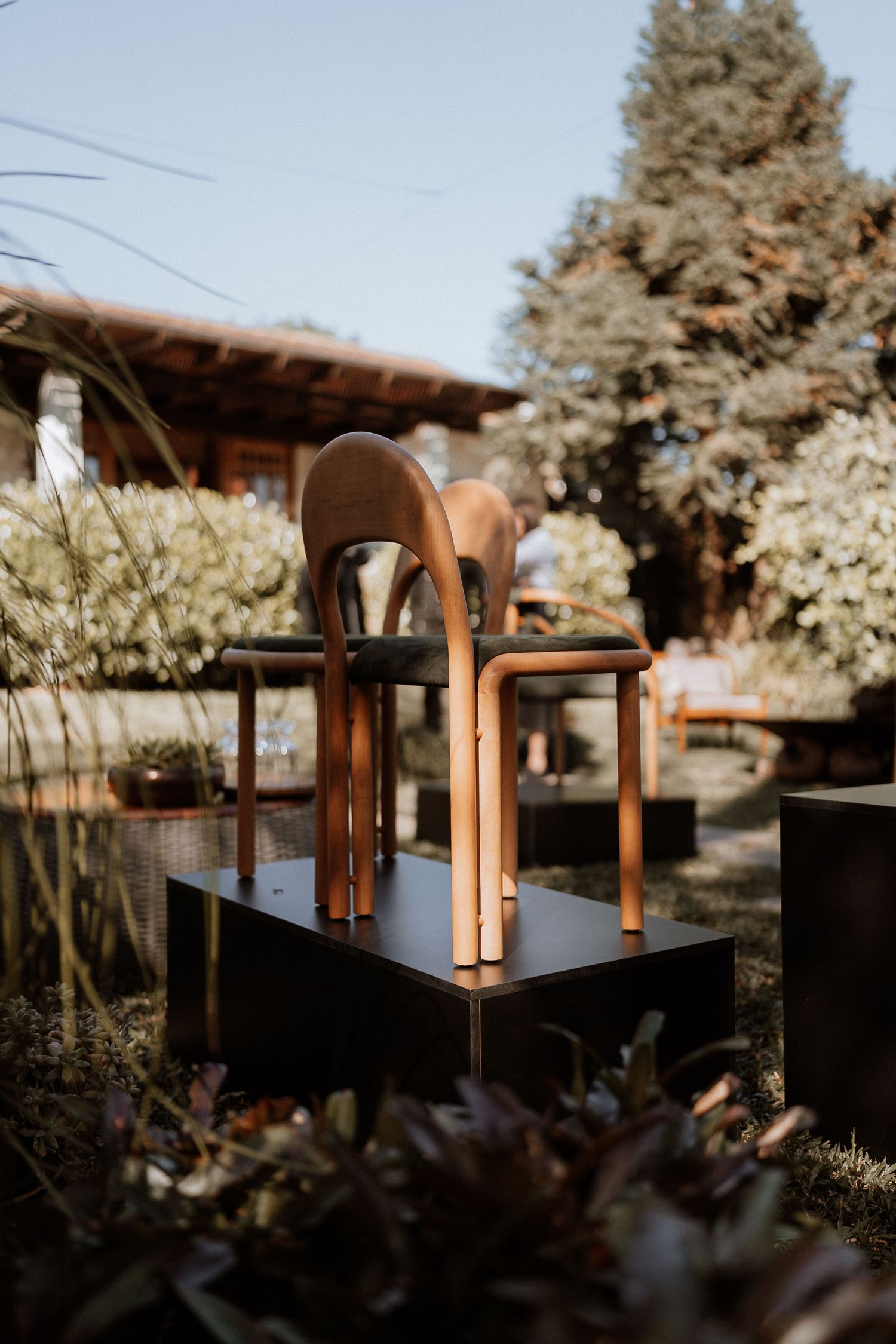 Outdoor dining setup with modern furniture against a rustic architectural backdrop.