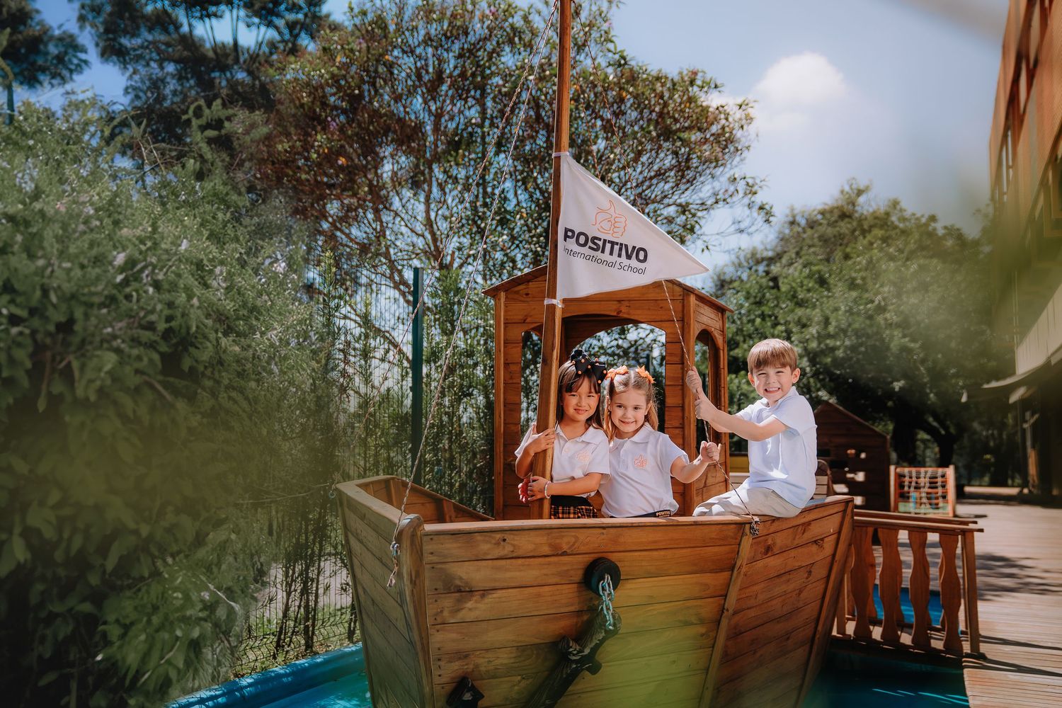 Crianças brincando em um barco de madeira em um parque. Campanha para instituição de ensino.
